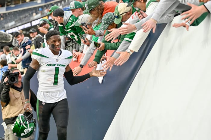 Sauce Gardner high-fives fans after a game with the Jets.